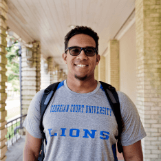 Young man wearing a GCU Lions t-shirt and smiling