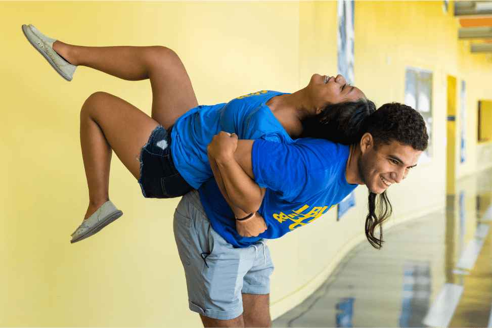 Male student lifting female student on his back
